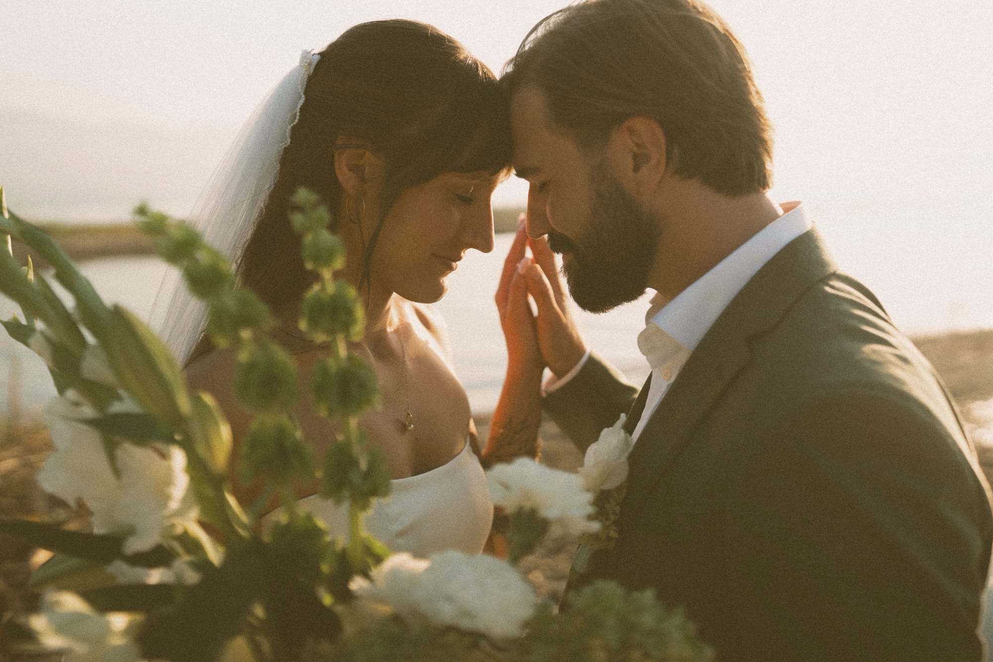 Bride and groom foreheads together at golden hour beside Okanagan Lake, a Kelowna wedding
