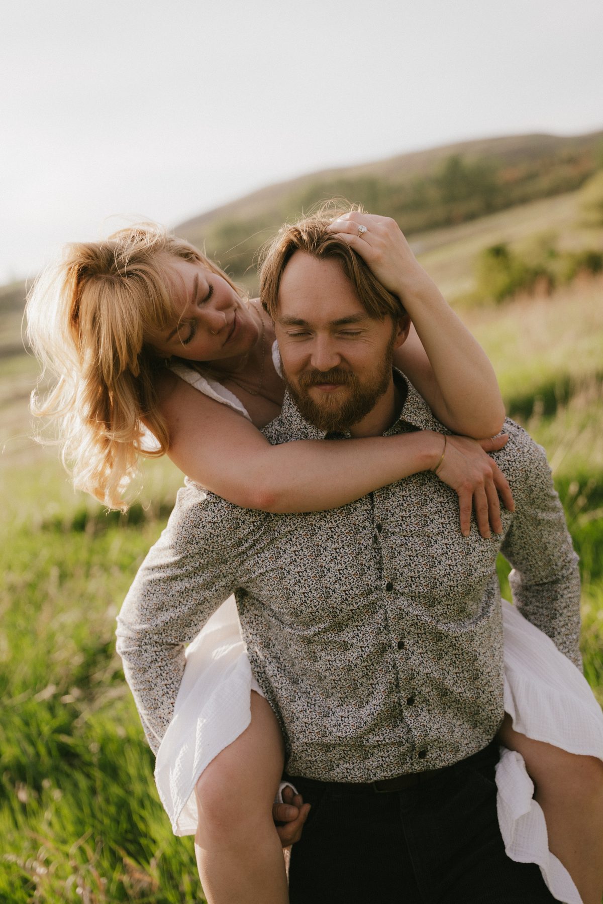 She rides on his back through long spring grass, laughing, an Okanagan hillside rising behind them