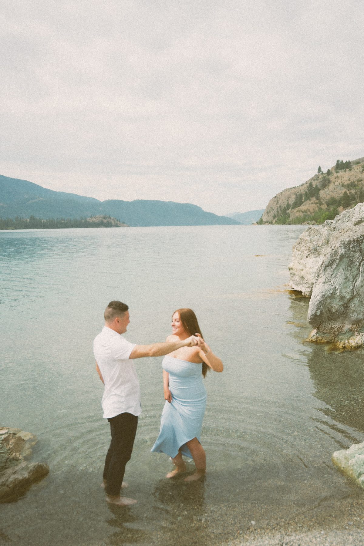 He turns her through the shallows of Okanagan Lake, her blue dress trailing in the water