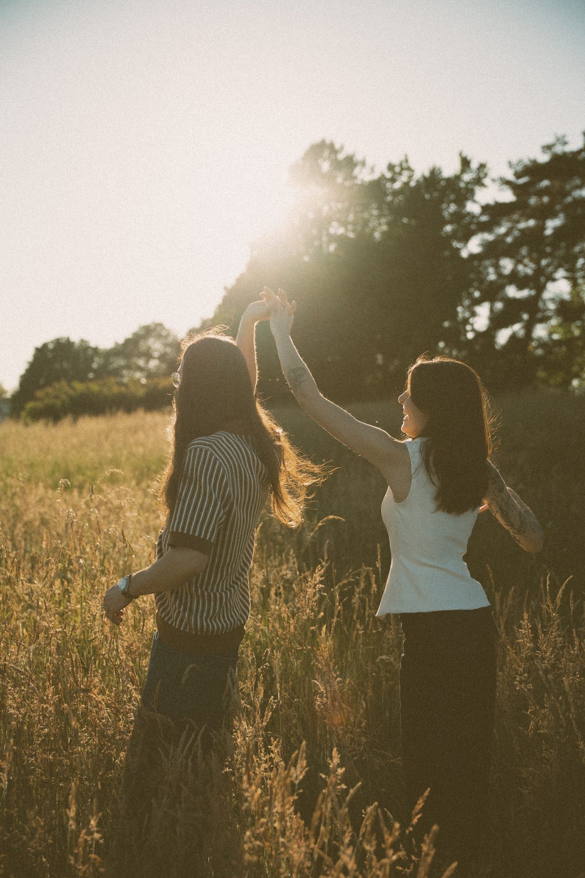 He spins her through a golden Garry oak meadow on Vancouver Island, backlit by the evening sun