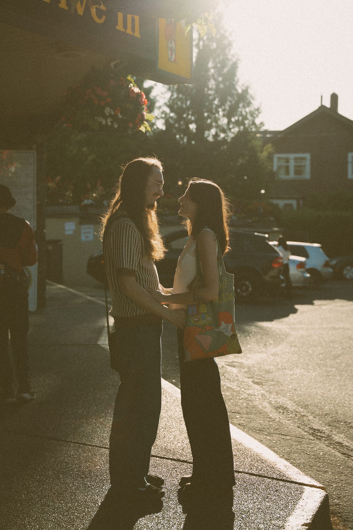 Couple standing forehead to forehead outside a Victoria drive-in at golden hour