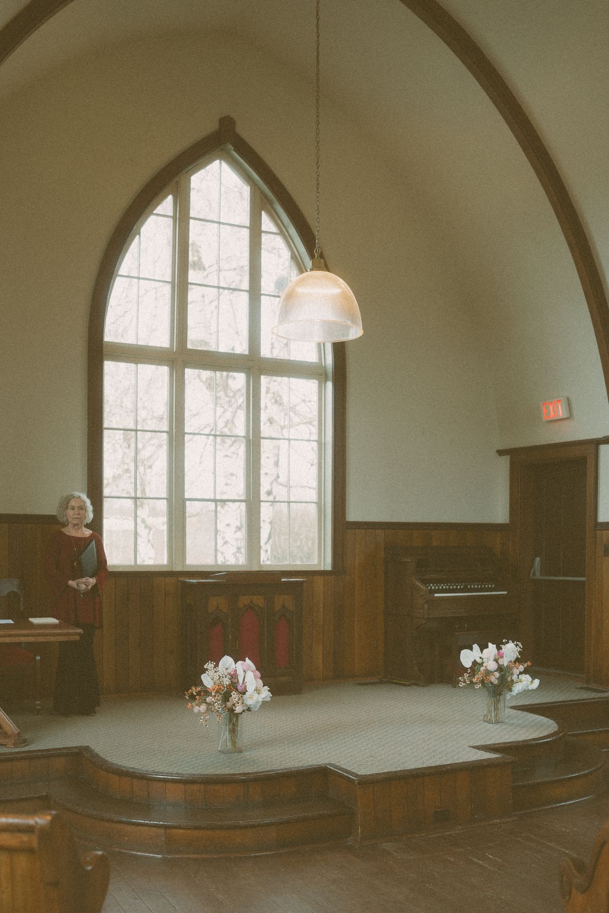 The church interior with its tall arched window and altar