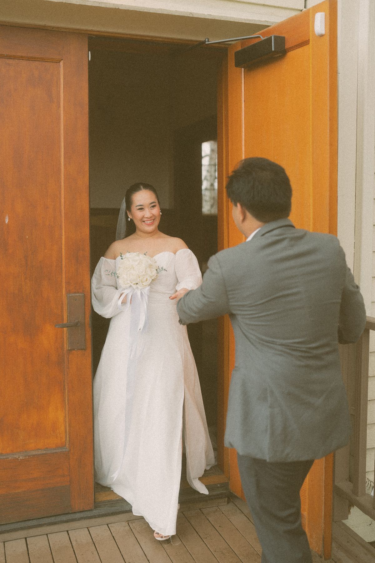 Groom meeting the bride at the doorway in the warm light