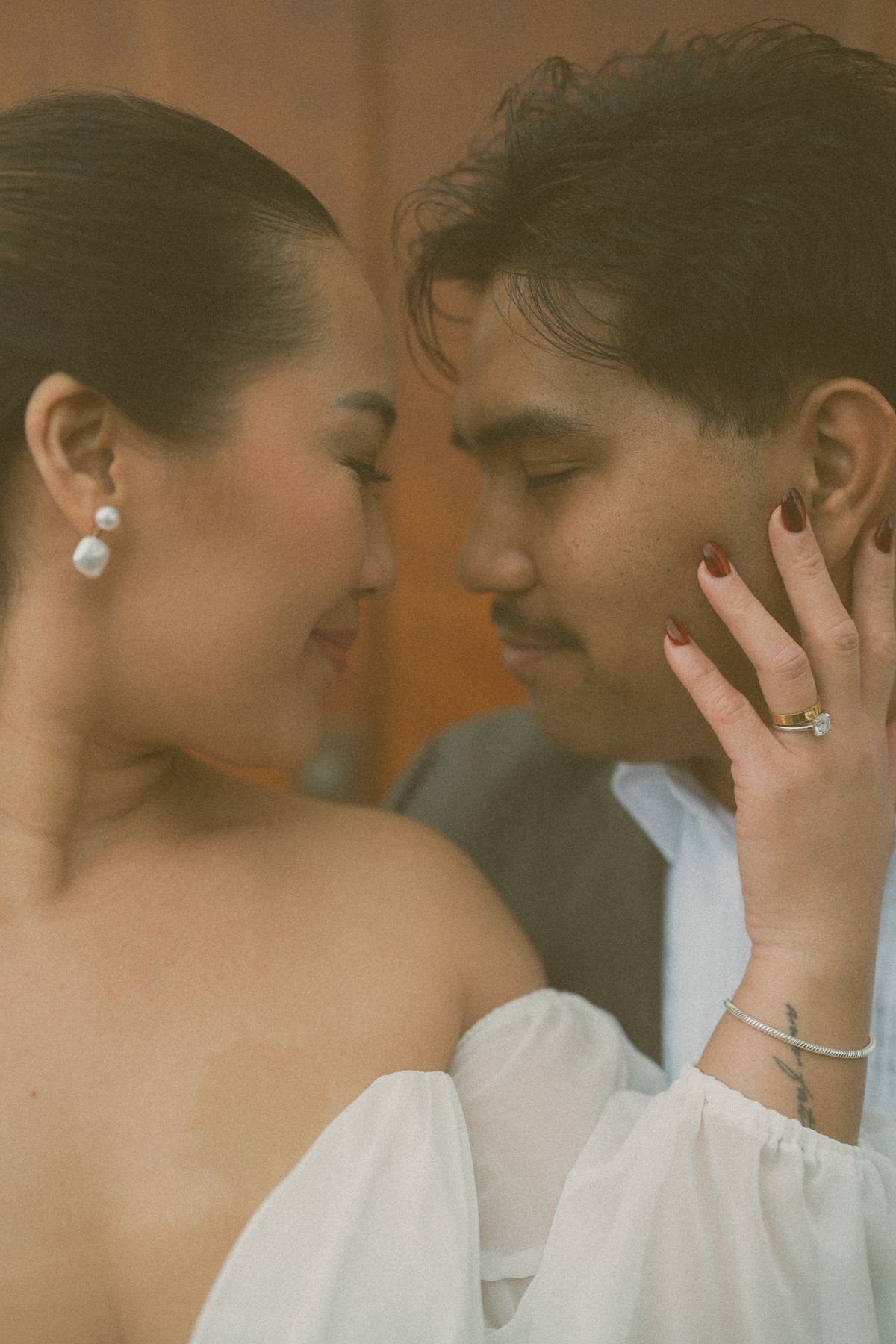 Intimate portrait of the bride's hand on the groom's face