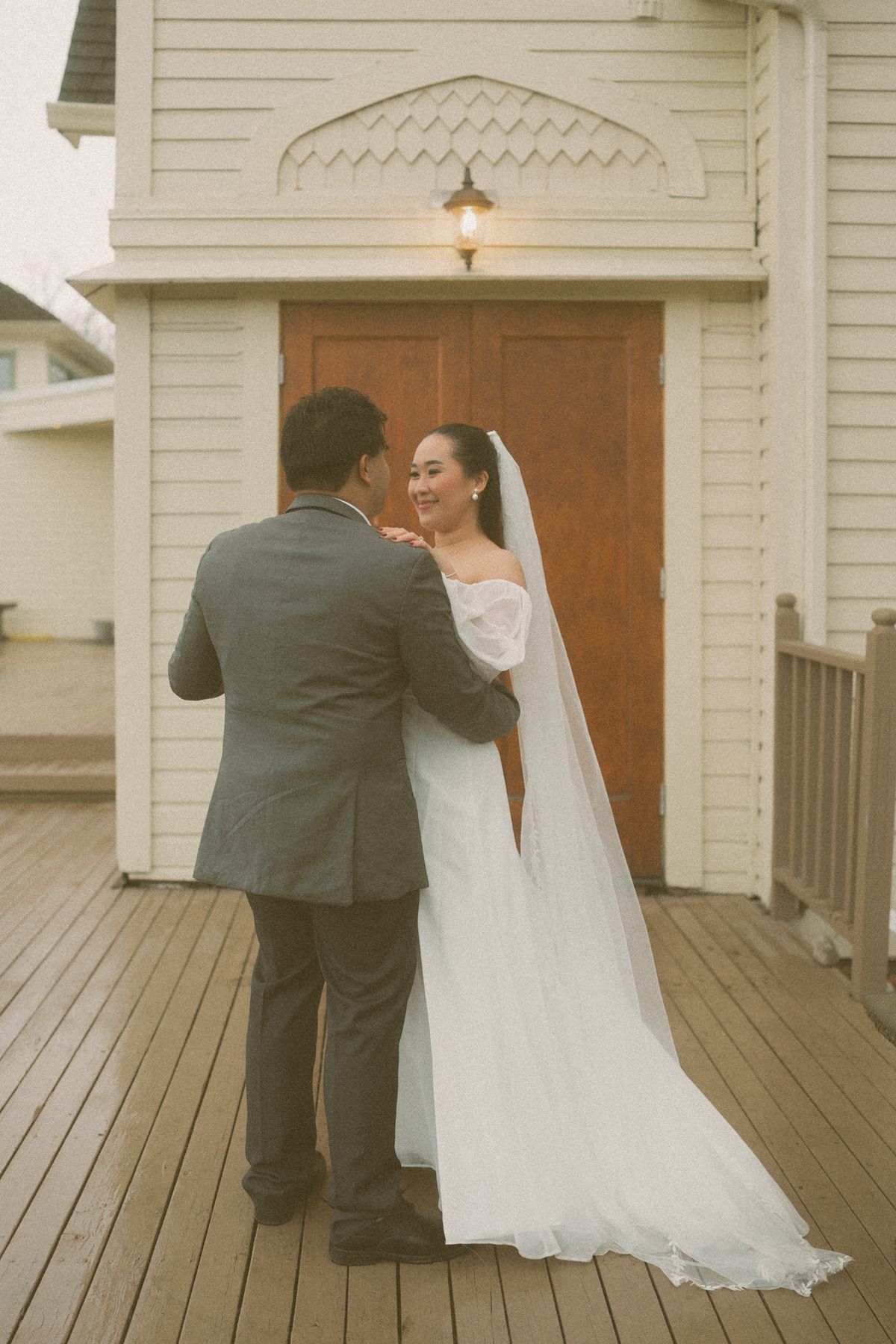 The couple embracing on the church porch