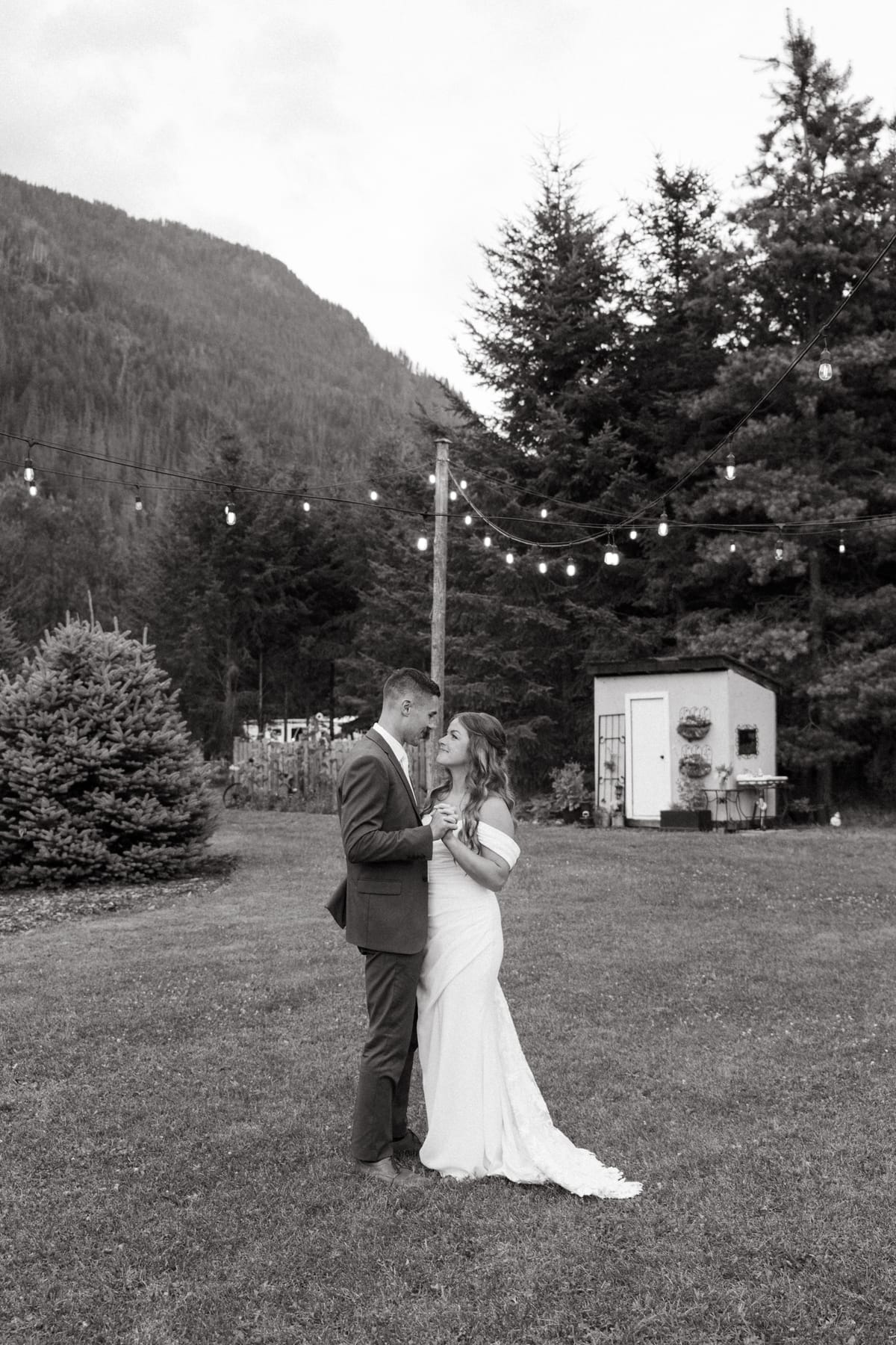 Black and white of Kendra and Rory's private dance on the lawn under string lights