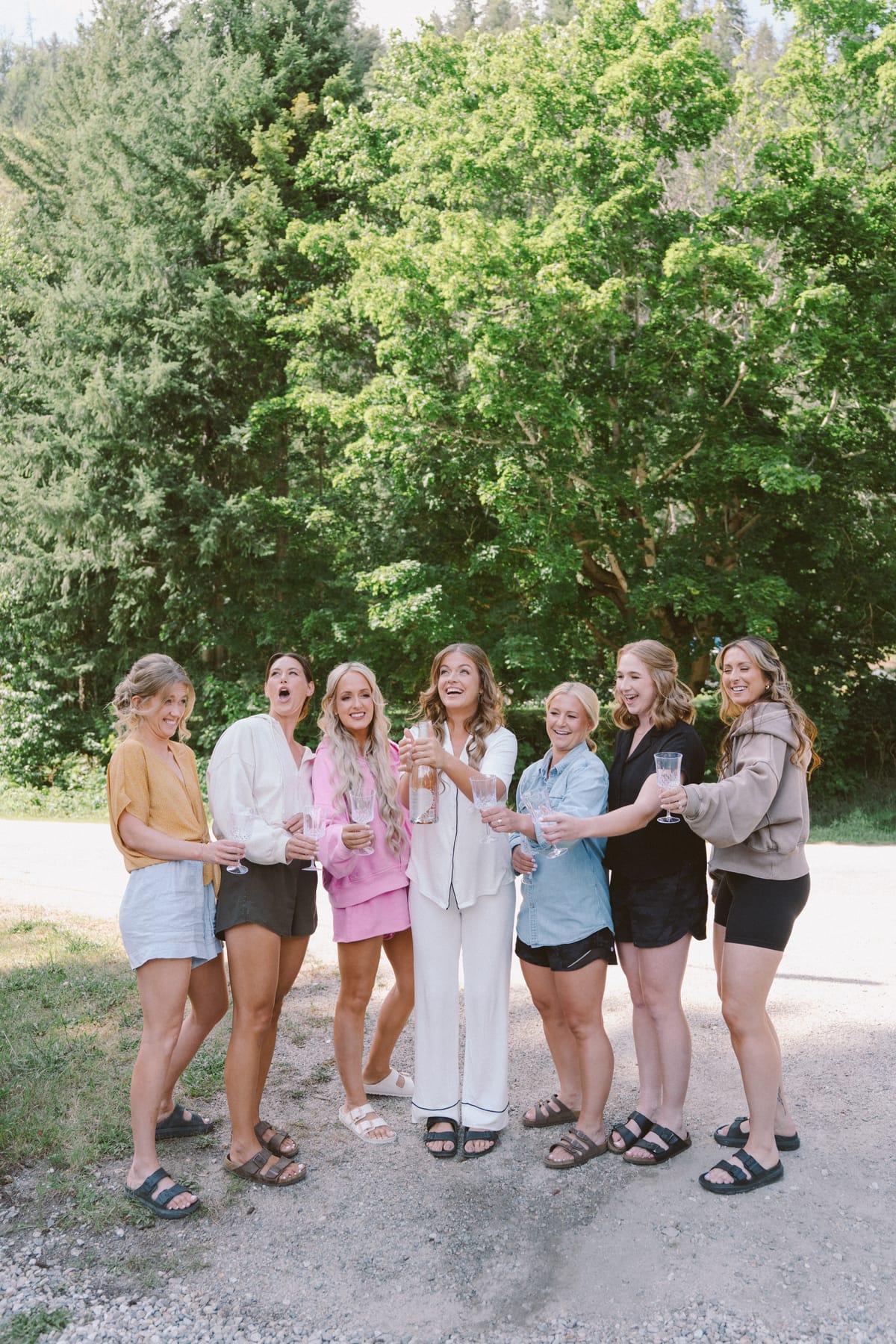 Kendra and her bridesmaids laughing together with drinks before getting ready