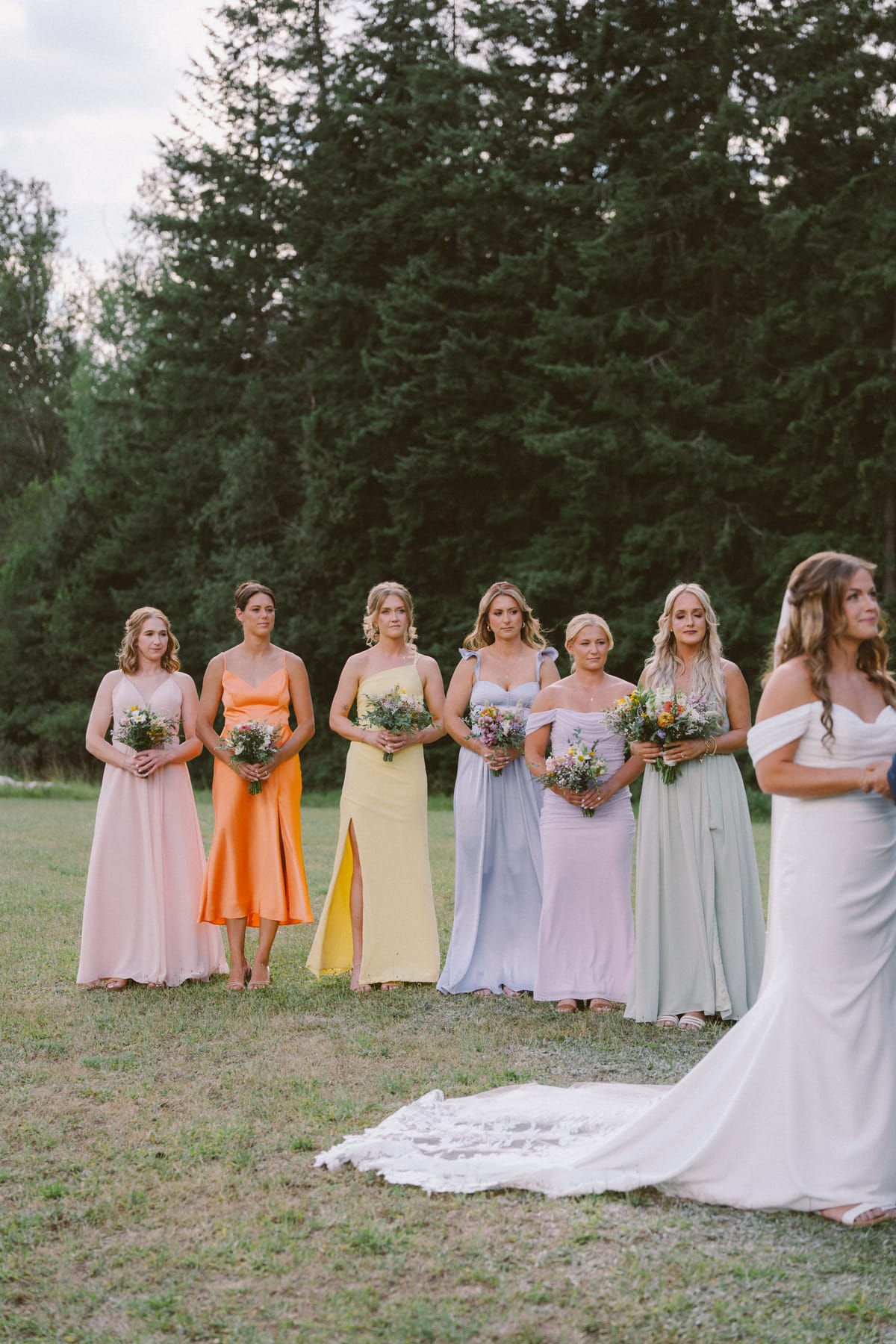 Kendra's bridesmaids in mismatched pastel dresses during the ceremony