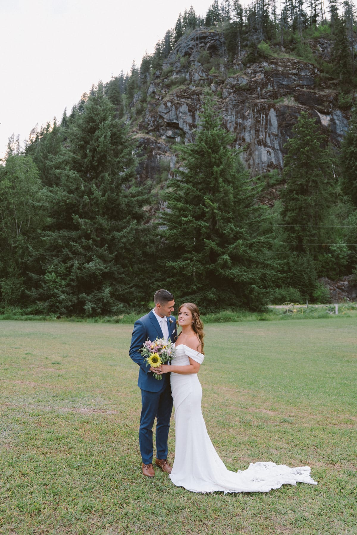 Kendra and Rory in the meadow below the towering rock face, her train across the grass