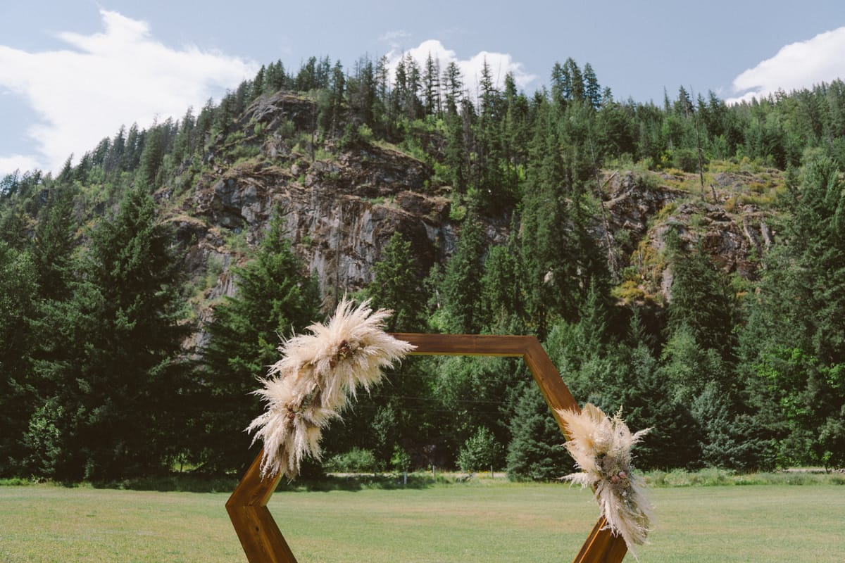 Pampas grass florals on the hexagonal ceremony arch with the mountain behind