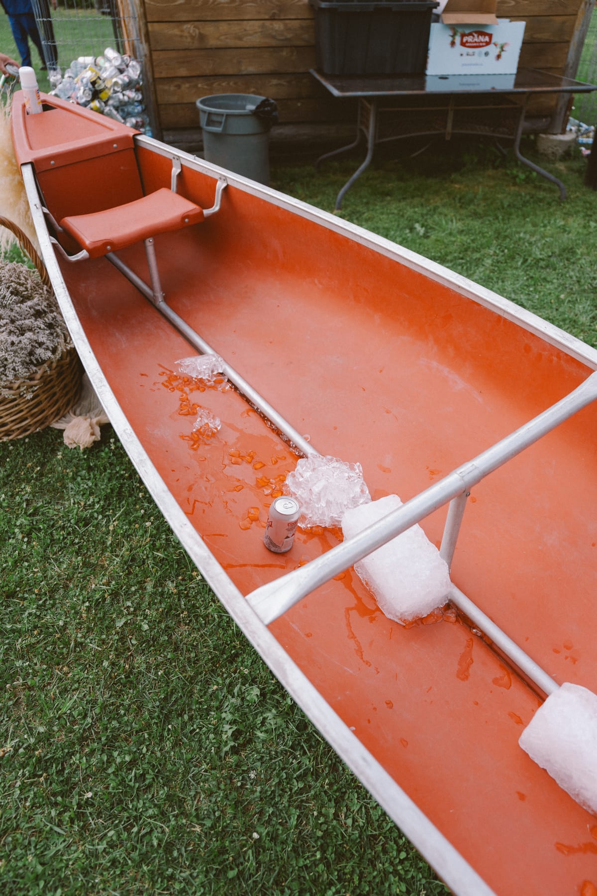 A red canoe filled with ice serving as the drinks cooler at the reception