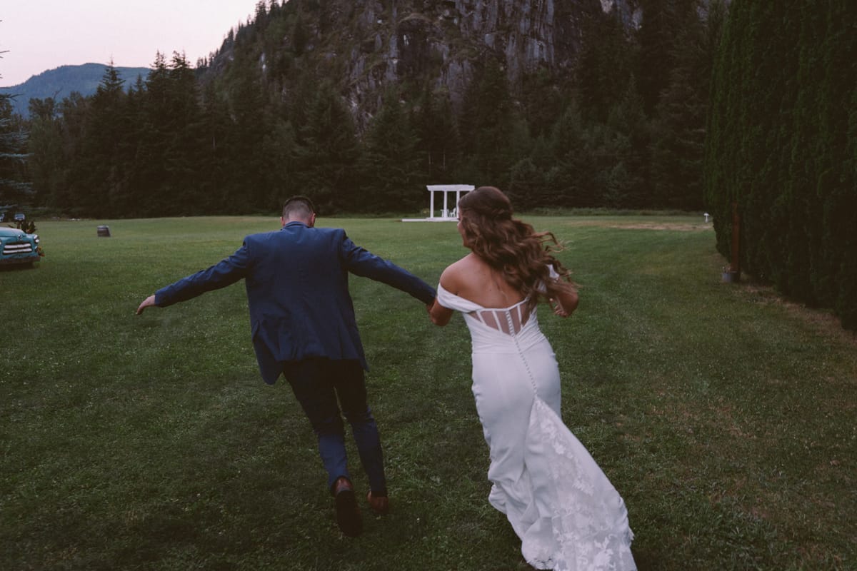 Kendra and Rory running across the lawn toward the white gazebo at dusk