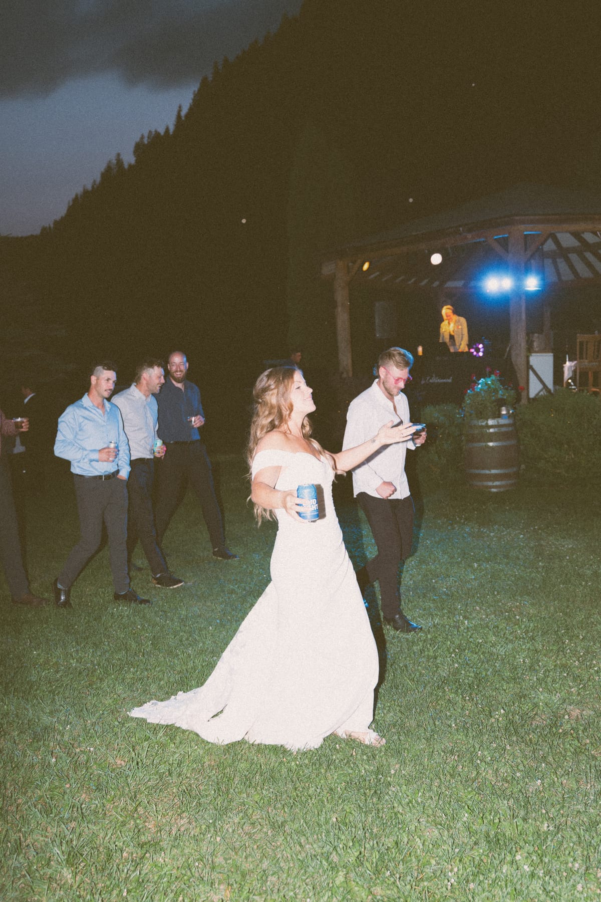 Kendra on the dance floor at night, the lit bar pavilion behind her