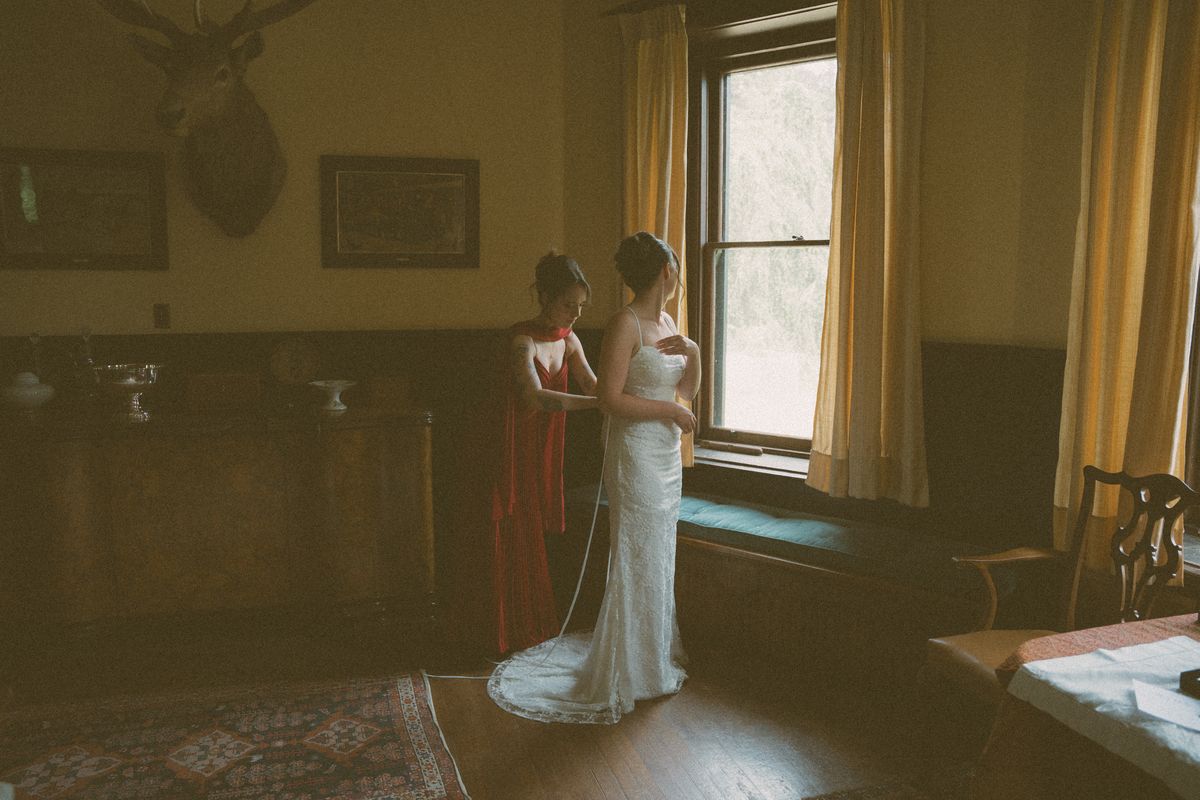 Bride getting ready in the heritage manor room by the window