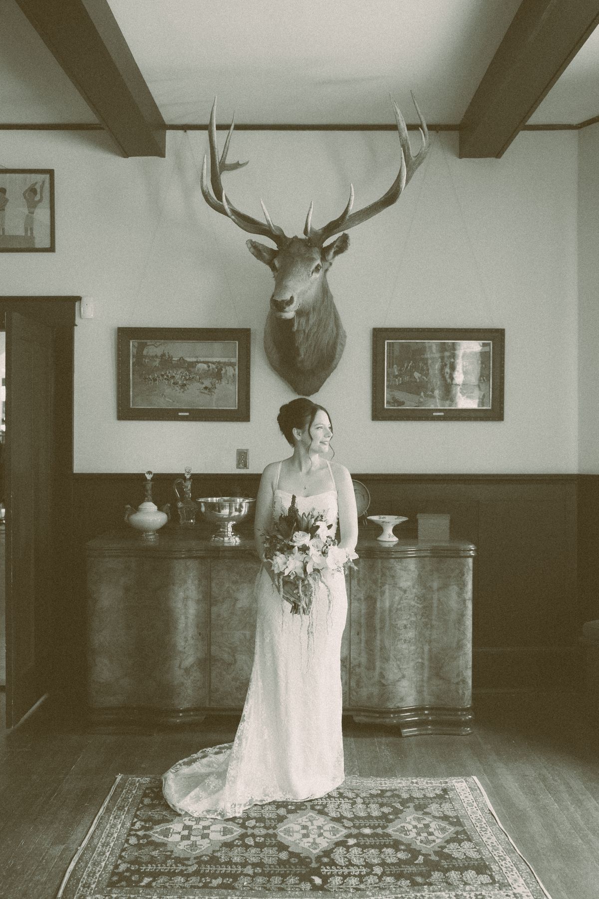 Bride standing in the manor's sitting room holding her bouquet