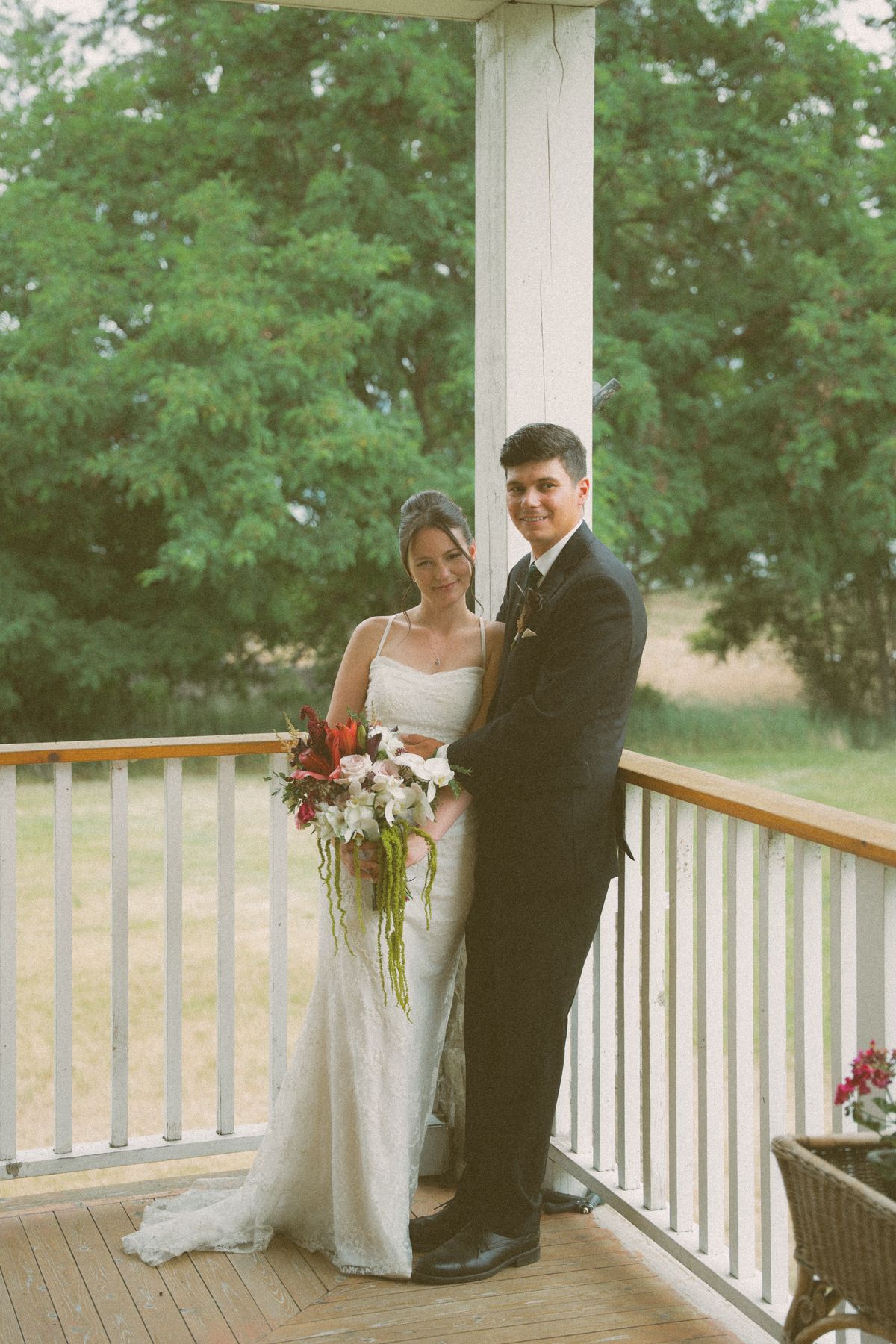 The couple embracing among the white columns of the verandah