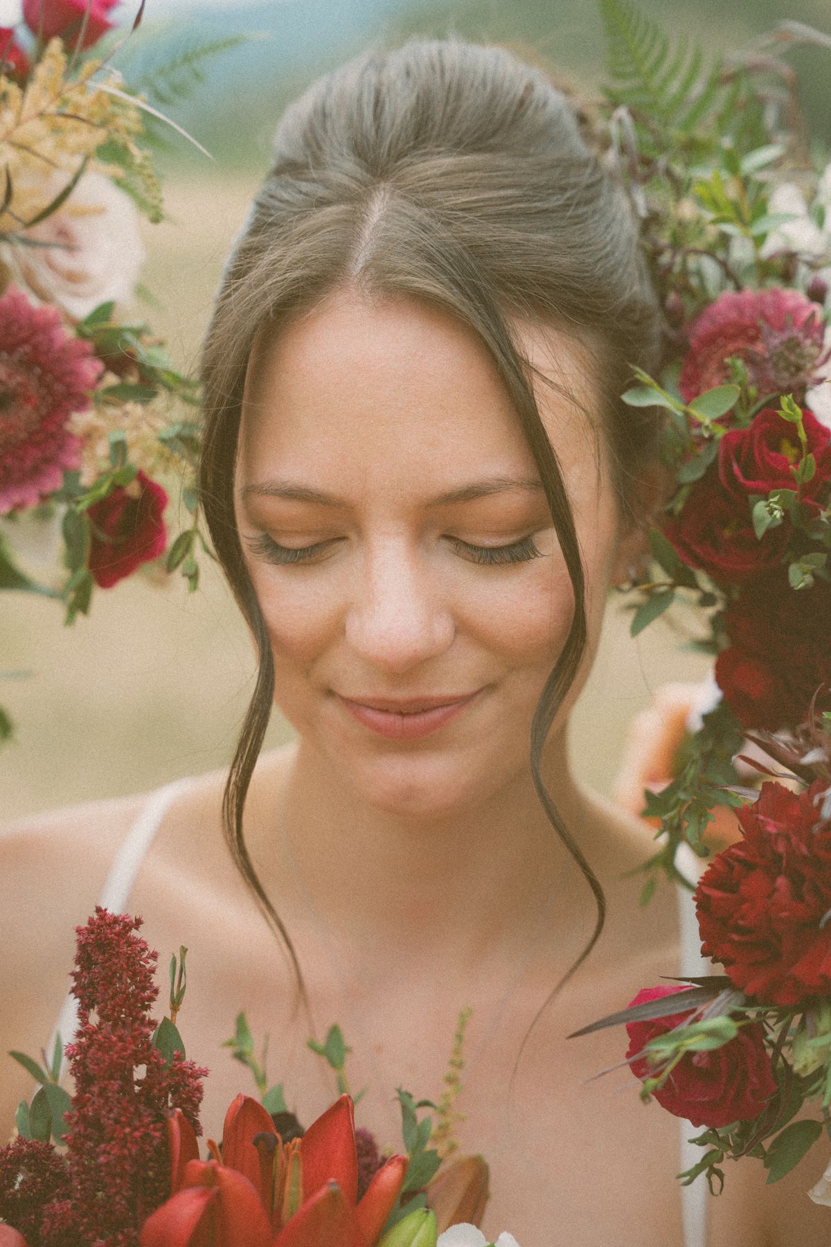 Bride's portrait framed by deep-red florals