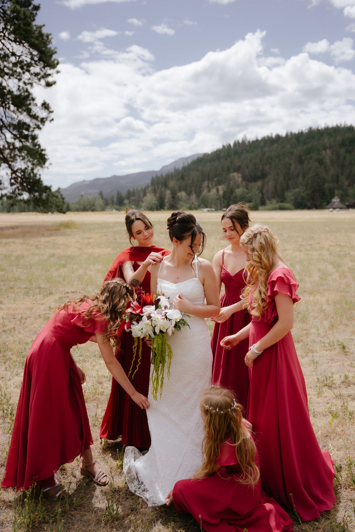 Bride with her bridesmaids in red gowns and red bouquets