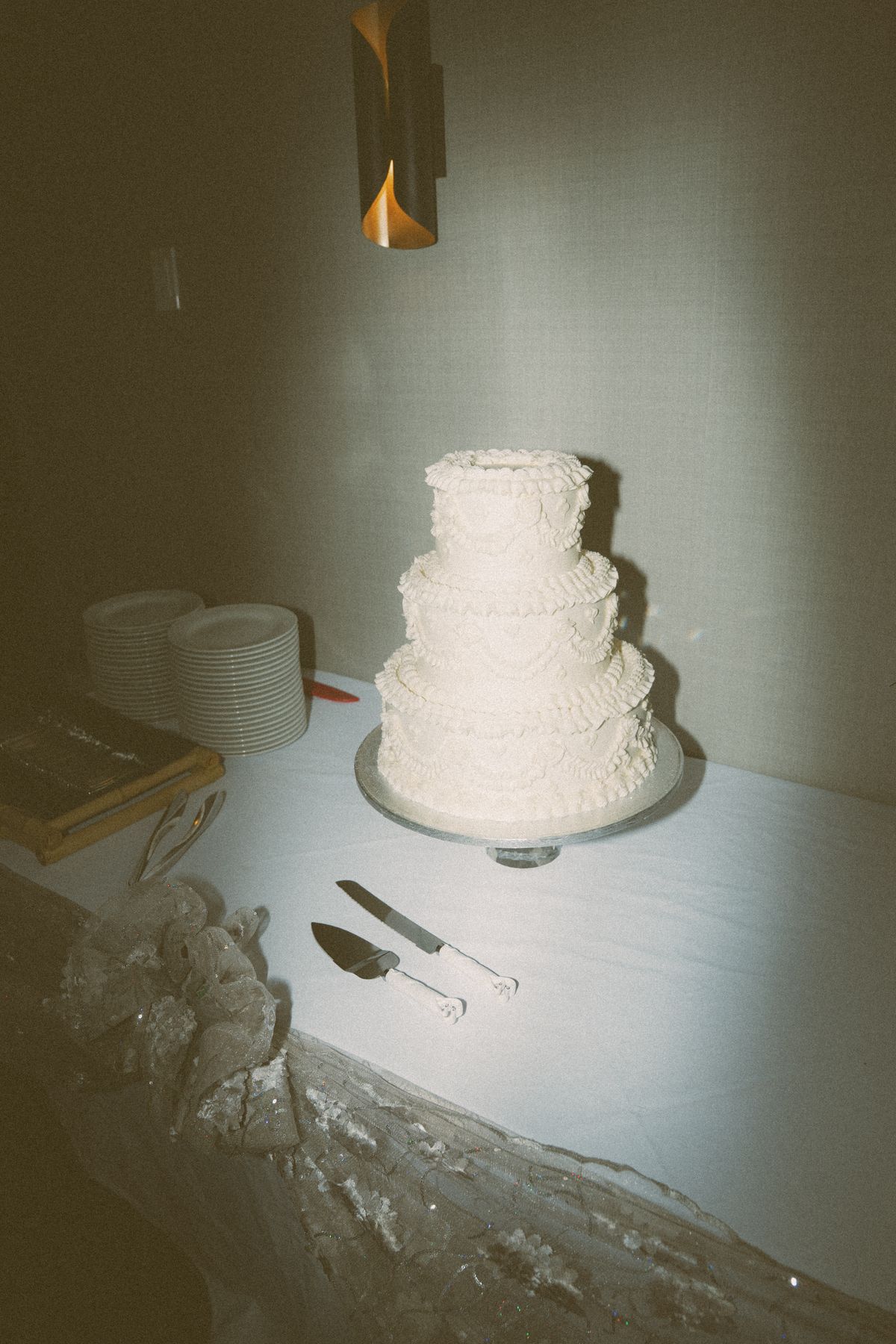The white tiered wedding cake set on its table