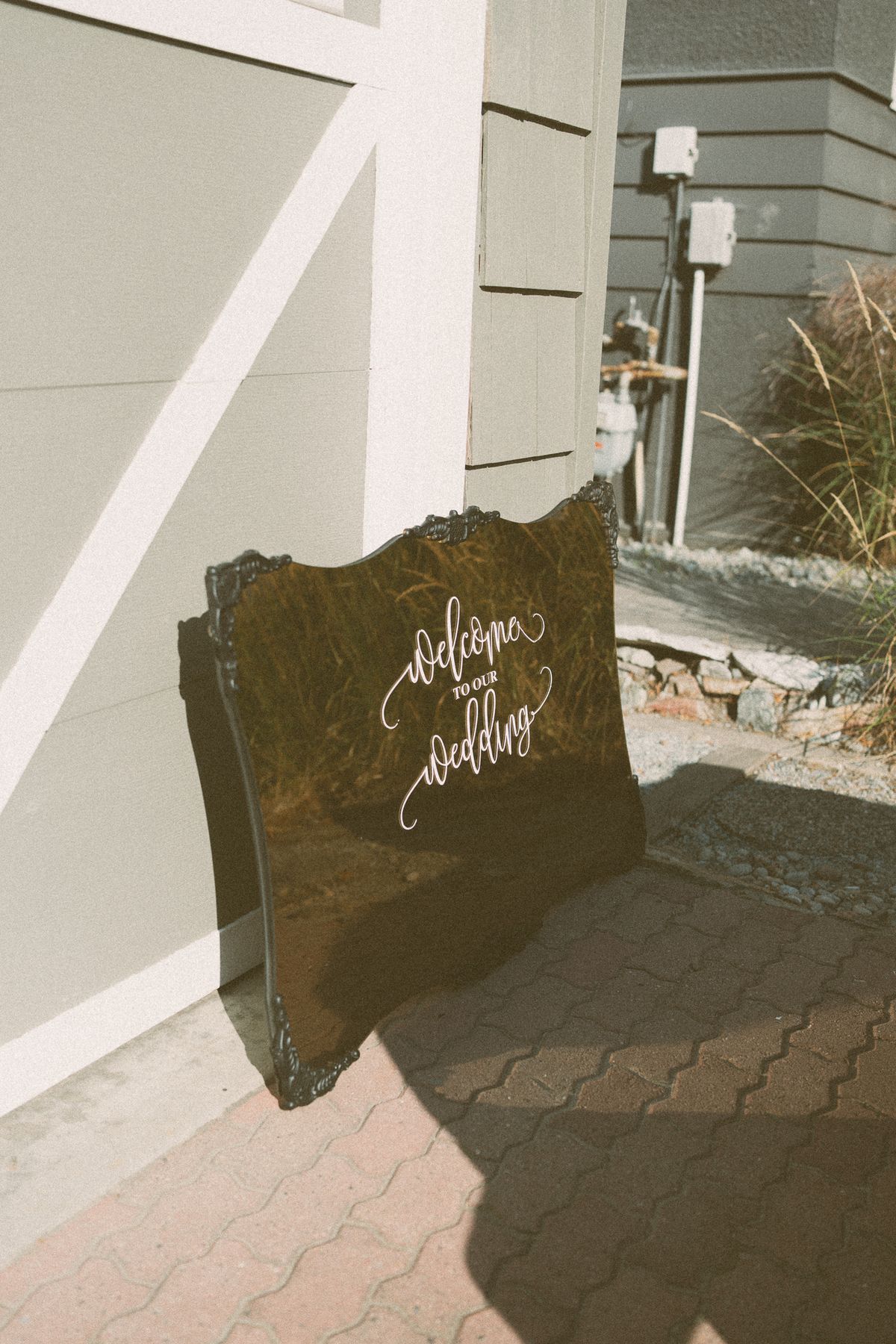 The gold welcome and seating sign leaning against the wall