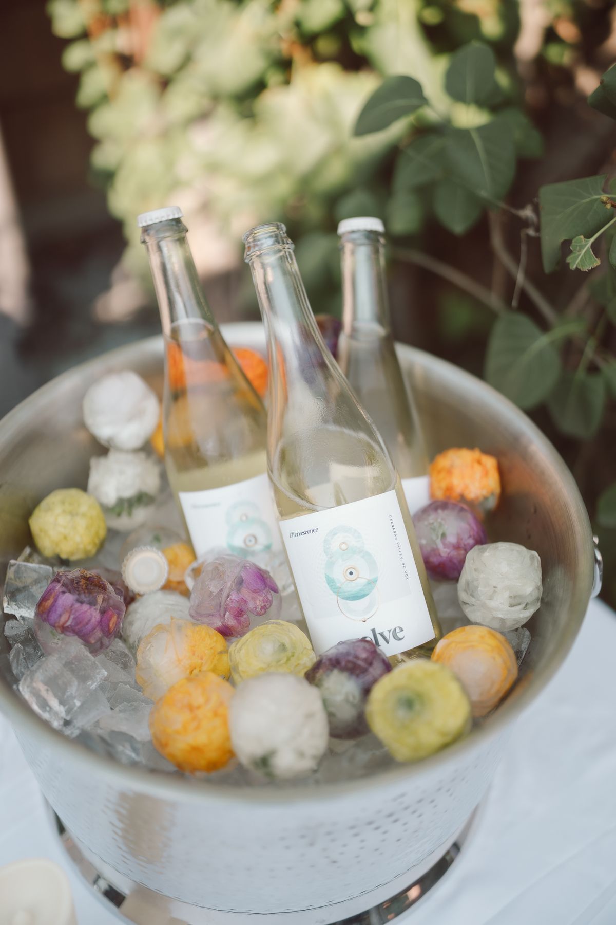 A drinks bucket dressed with citrus and flowers beside a table number