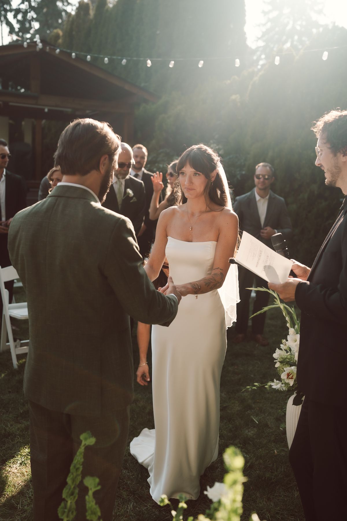 The couple holding hands as the officiant reads during the ceremony