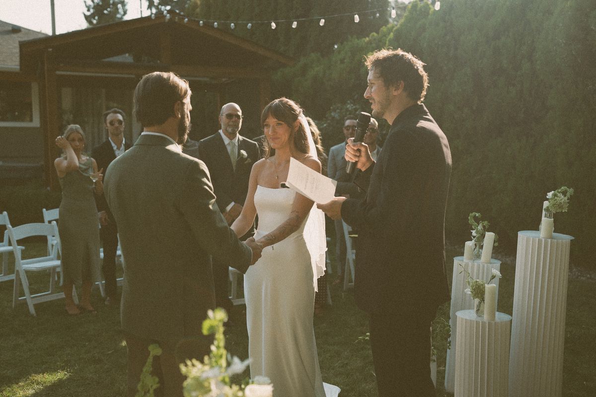 Bride and groom facing one another among the pillar candles