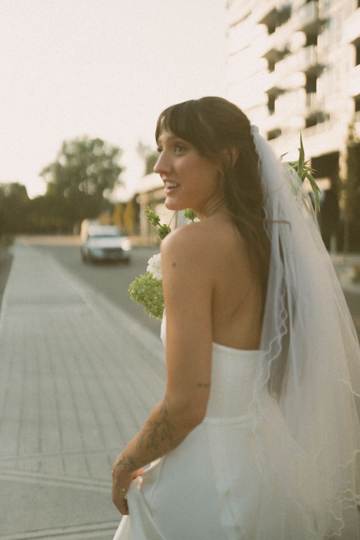 Bride's portrait on the path, glancing over her shoulder in her veil