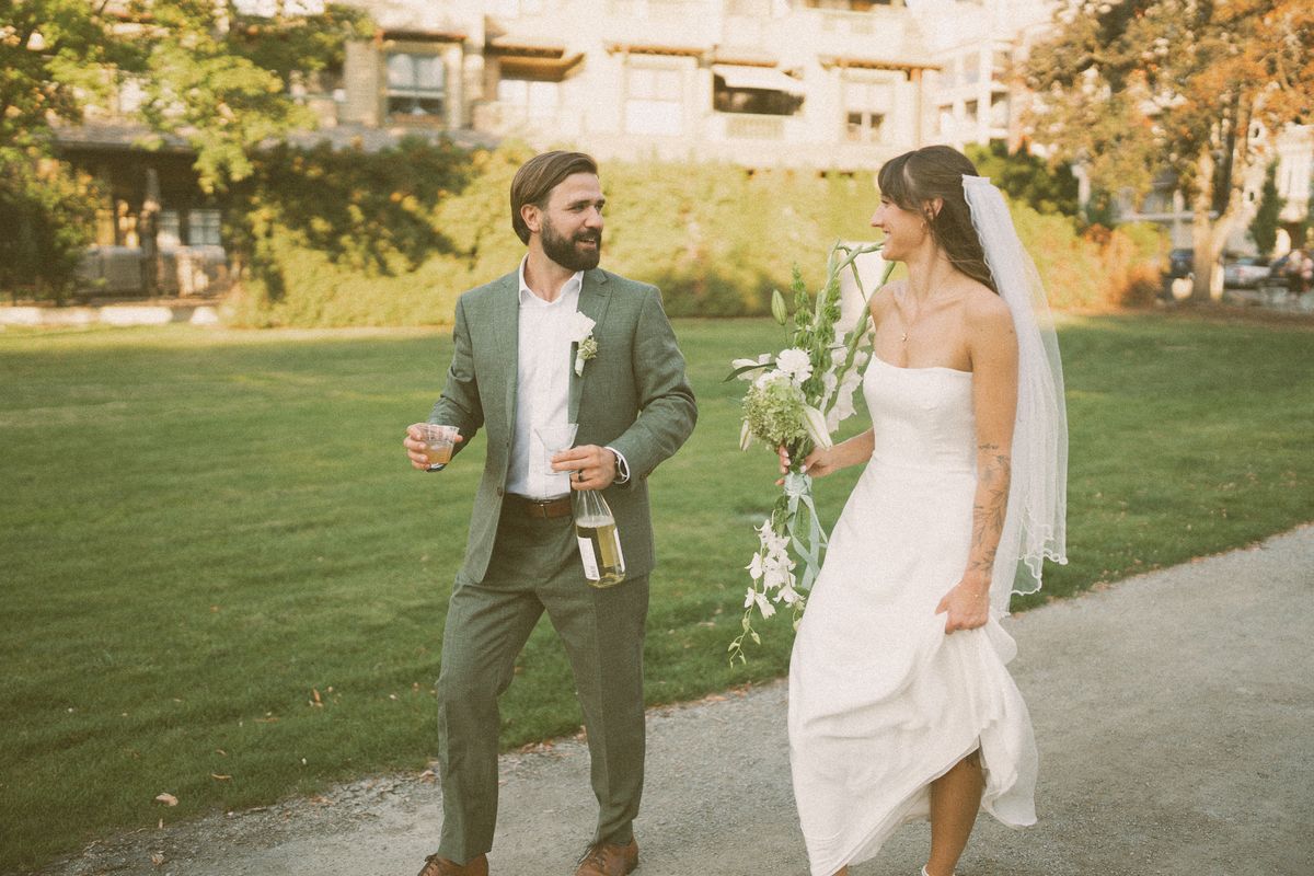 The couple on the lawn, the groom carrying champagne