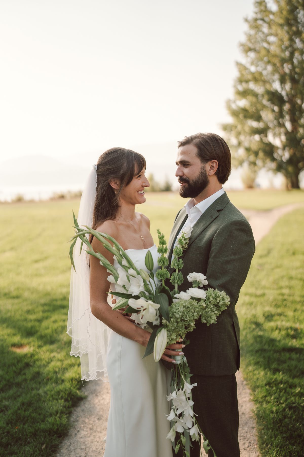 Bride and groom face to face on the path in the golden light