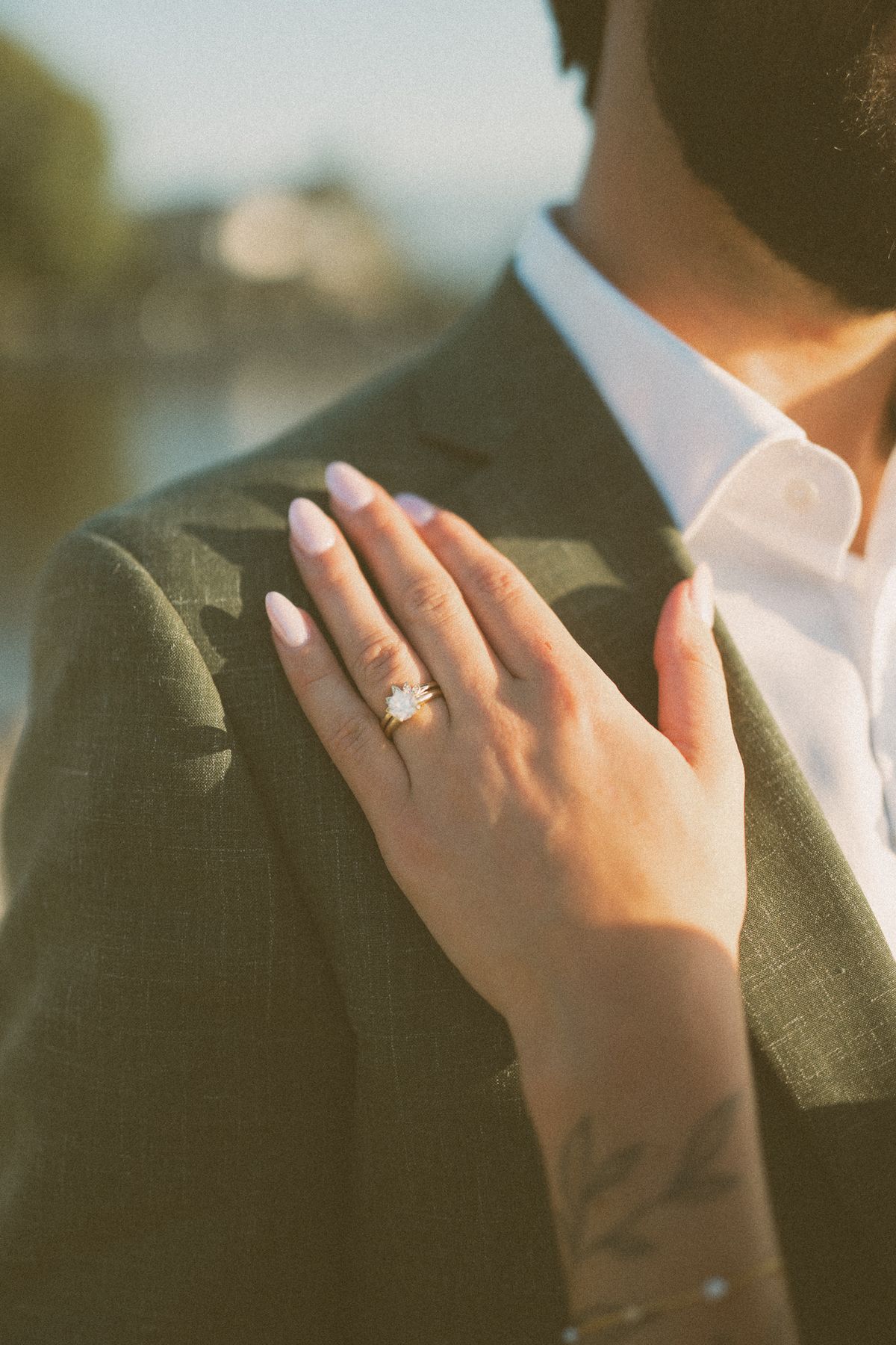 The bride's ringed hand resting on the groom's chest
