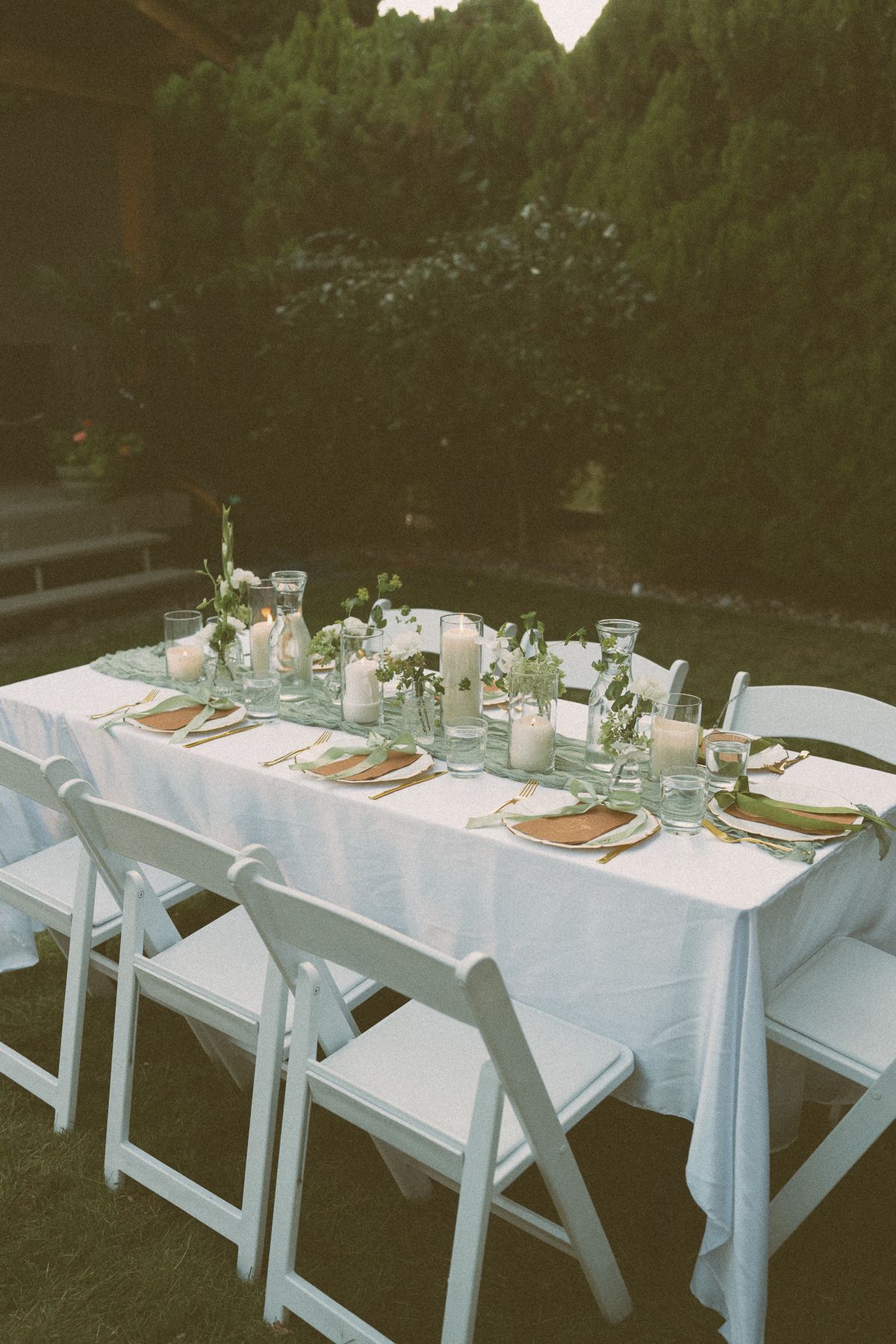 Reception table set with candles and string lights at dusk