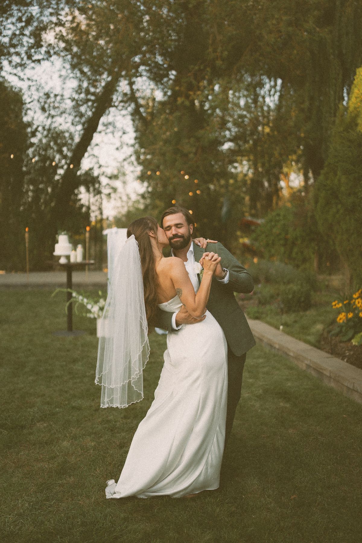 The couple dancing in the garden as evening falls
