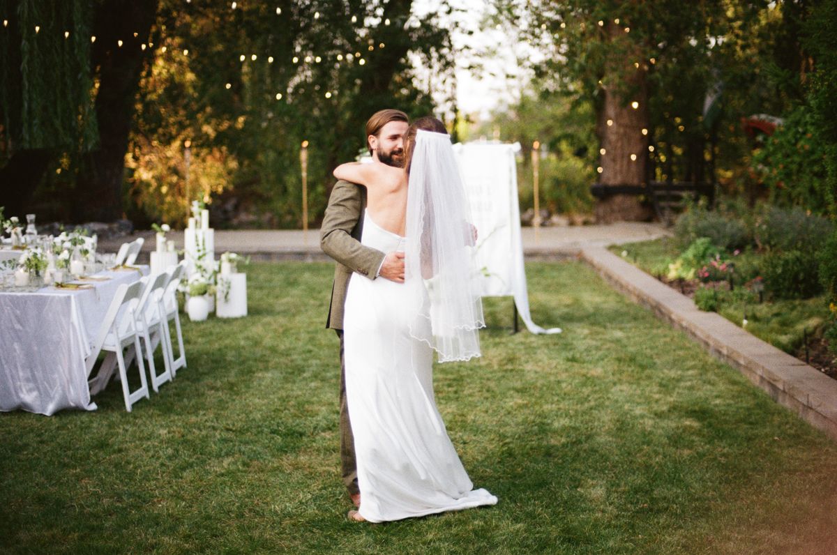The couple in the garden by the candlelit reception tables at Mission Creek
