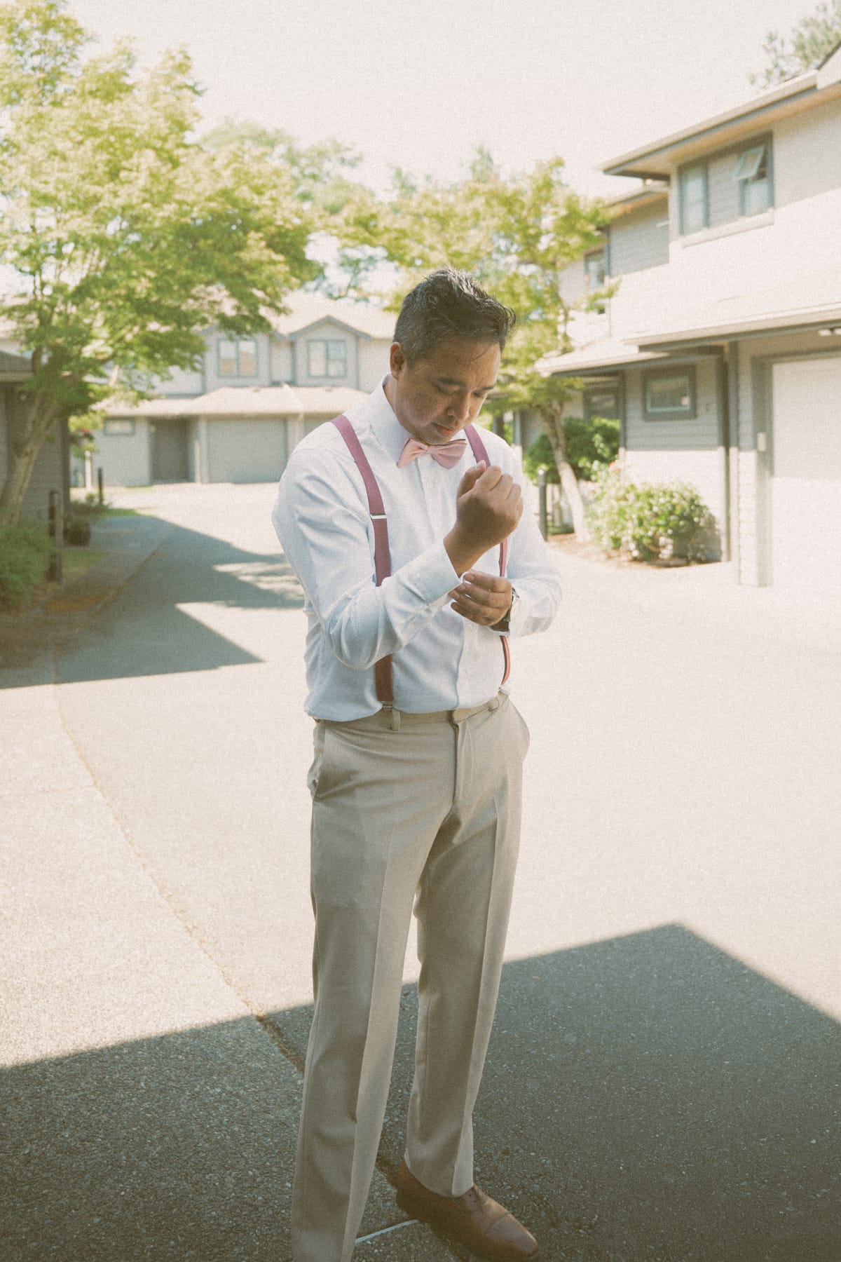 Vis fastening his cufflink in the driveway as he finishes getting ready