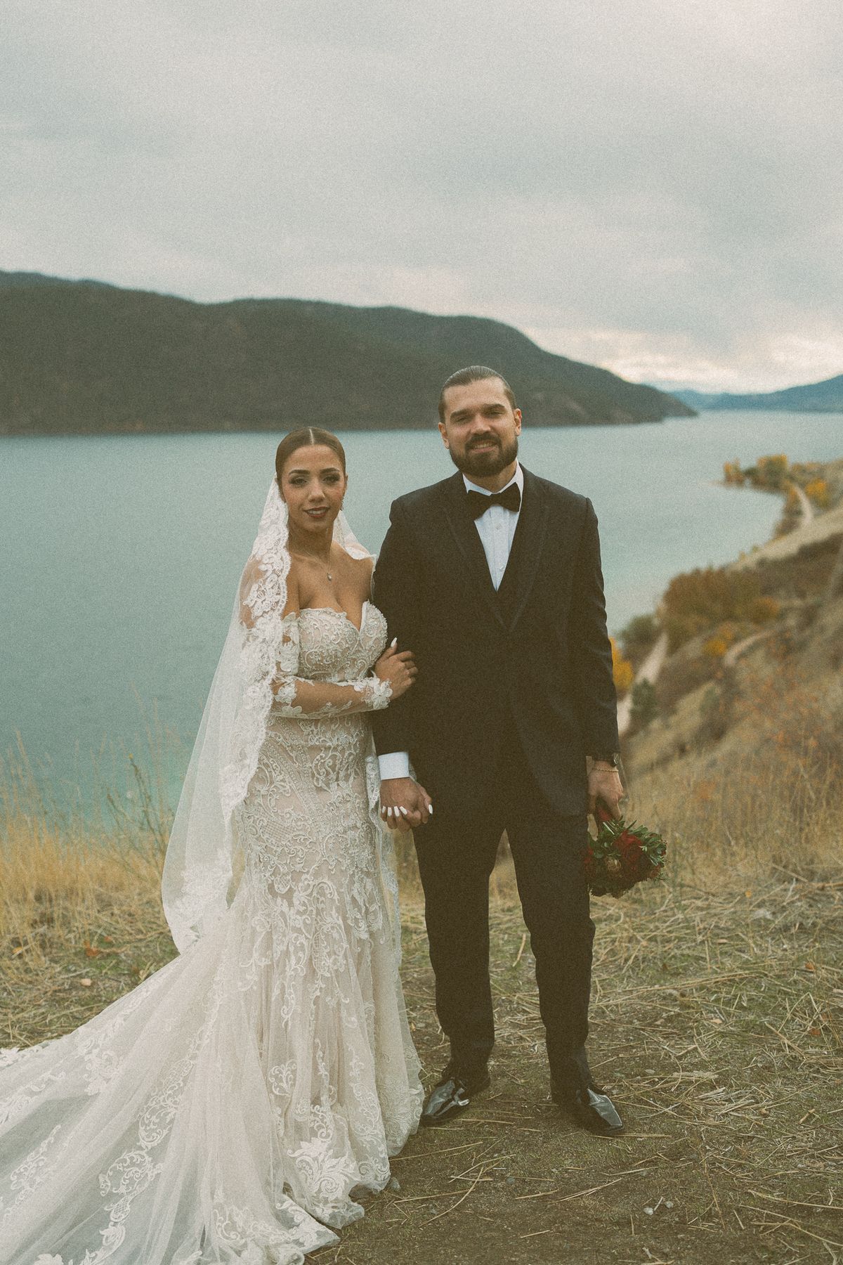 The couple standing on the autumn bluff at Kekuli Bay with the lake behind