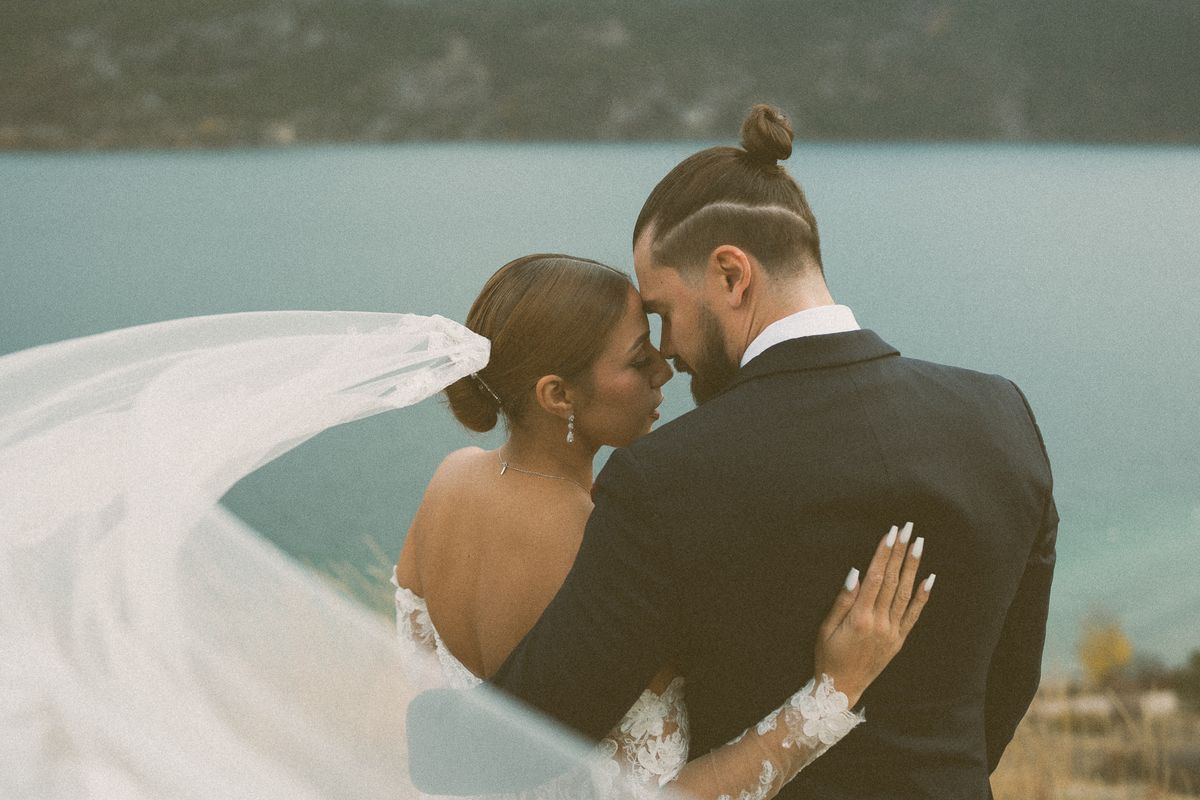 The bride's veil sweeping across the frame above the lake at Kekuli Bay