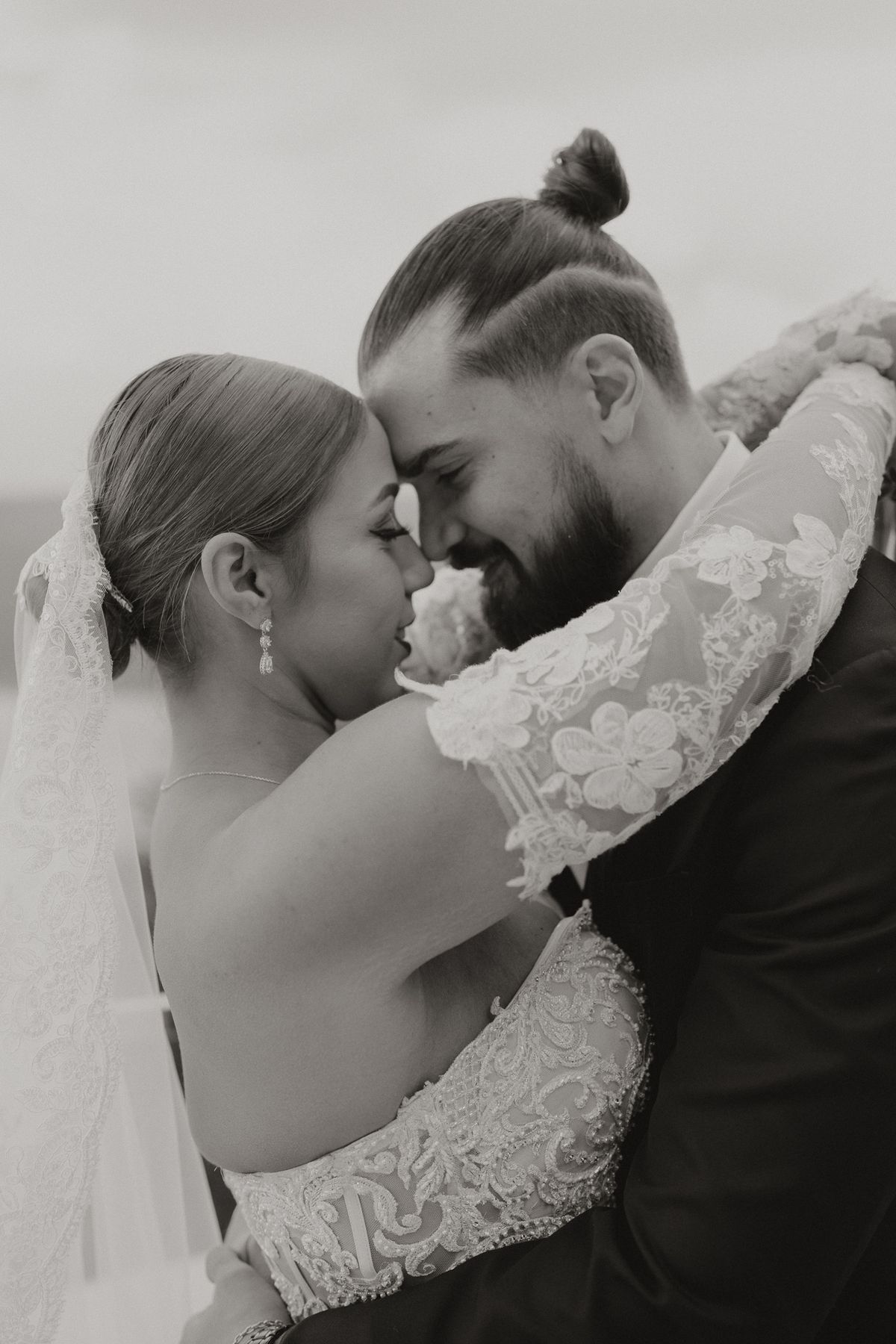 Black and white of the couple laughing in a close embrace