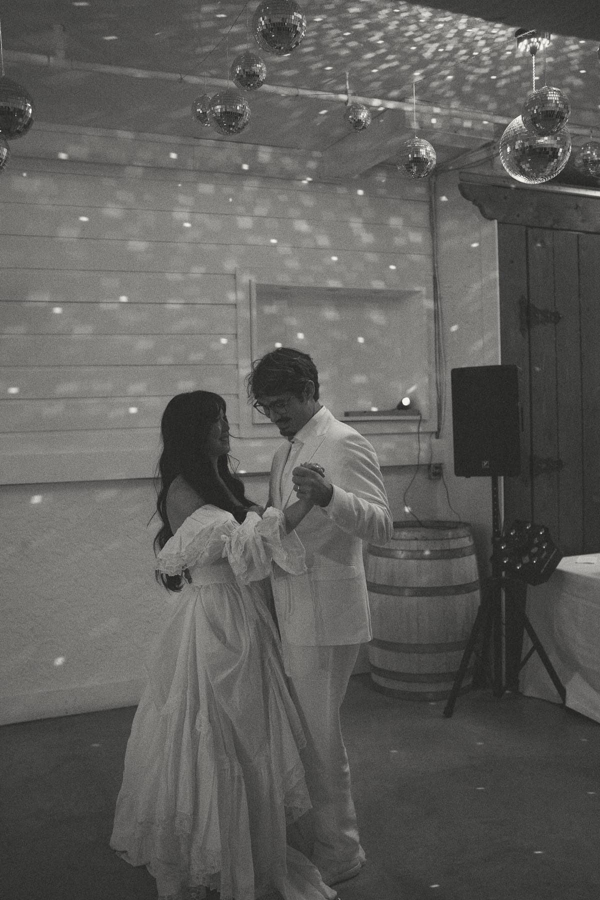 Black and white of Nina and Brandon's first dance under the disco balls