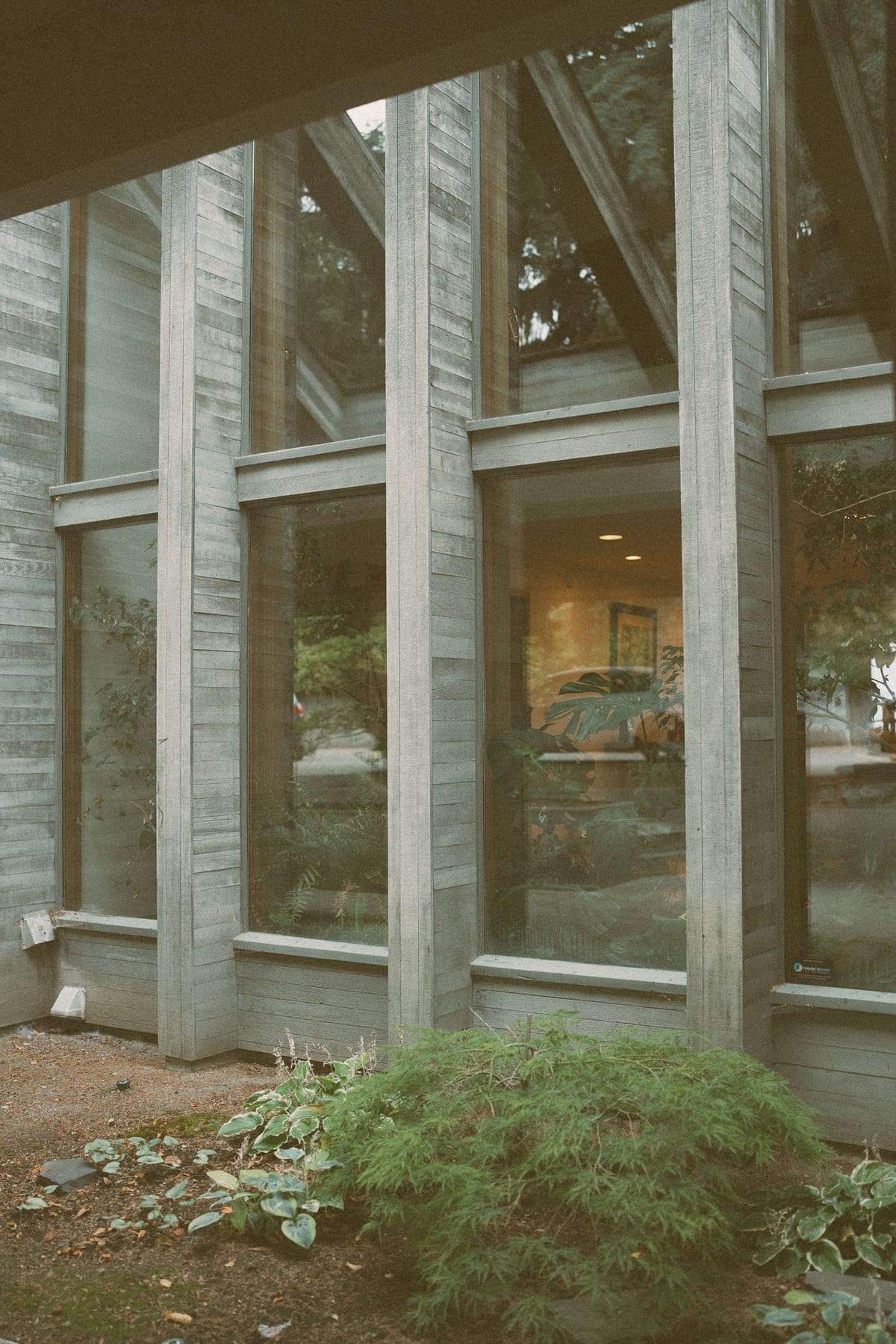 The timber-and-glass architecture of Summerhill Winery framed by greenery