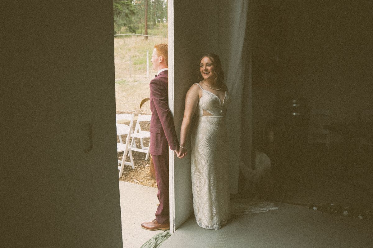 Bride and groom sharing a first touch around the doorway before the ceremony