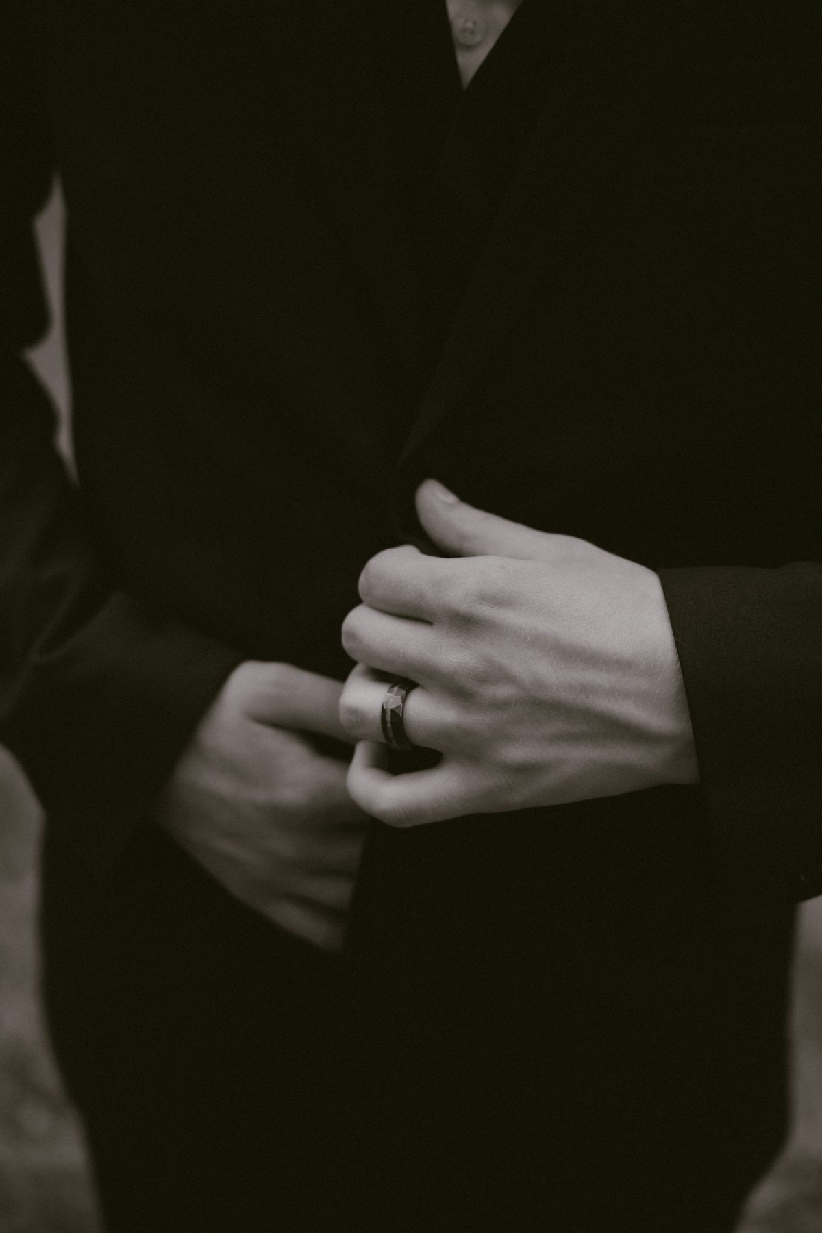 Close detail of the couple's hands and wedding rings