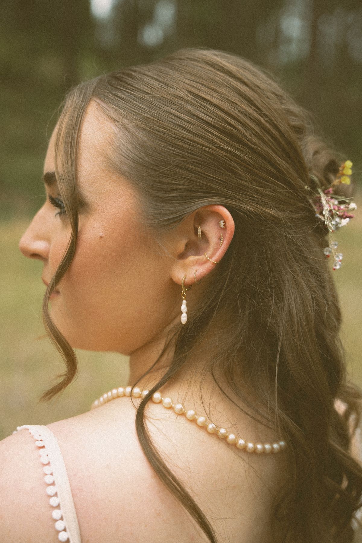 Profile portrait of the bride with a pearl strand down her back