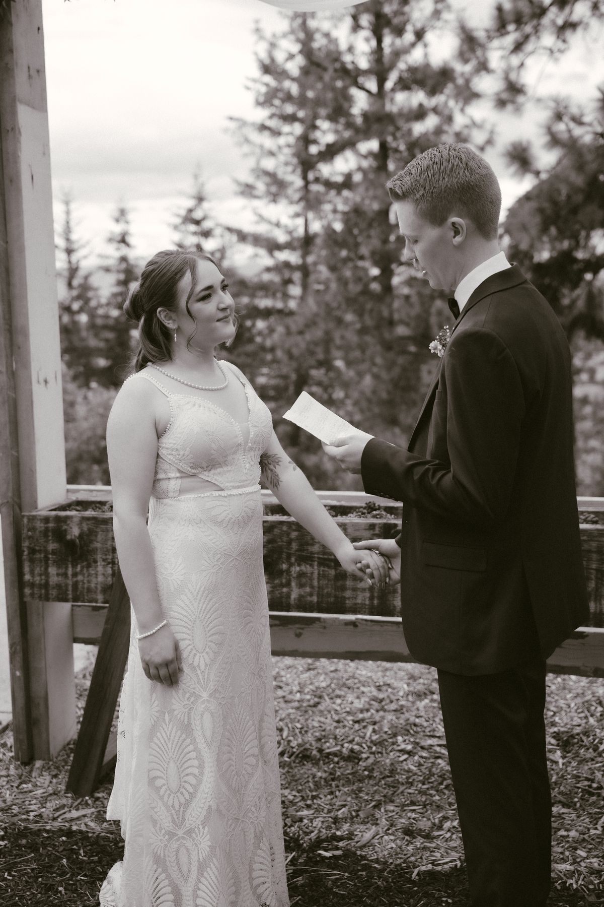 Black and white of the bride reading her vows to the groom